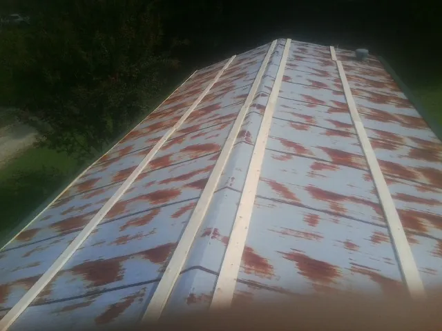 Rusted metal roof panels with new wood purlins before replacement — Storm Damage Roof Repair in Saint Marks by Roofing Brothers