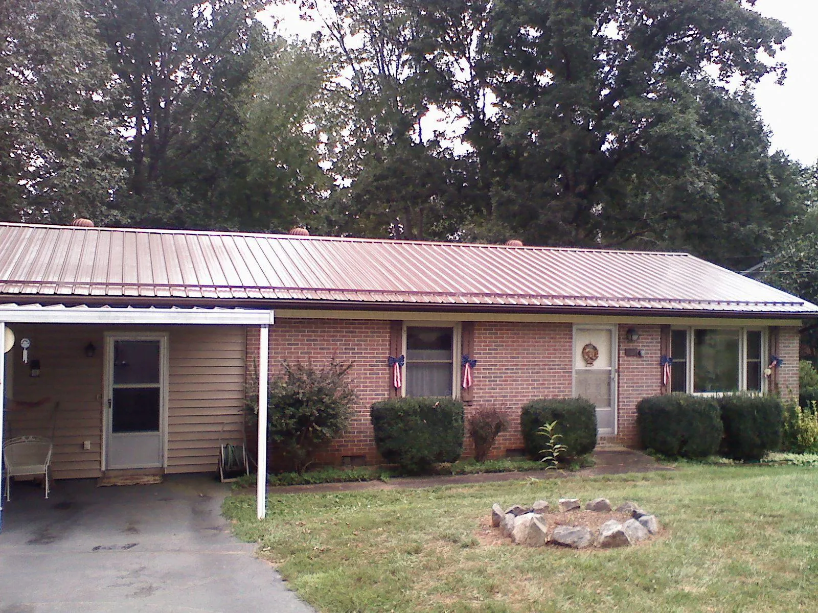 Bronze metal roof and carport on a brick ranch home — Roof Repair work by our crew in Saint Marks